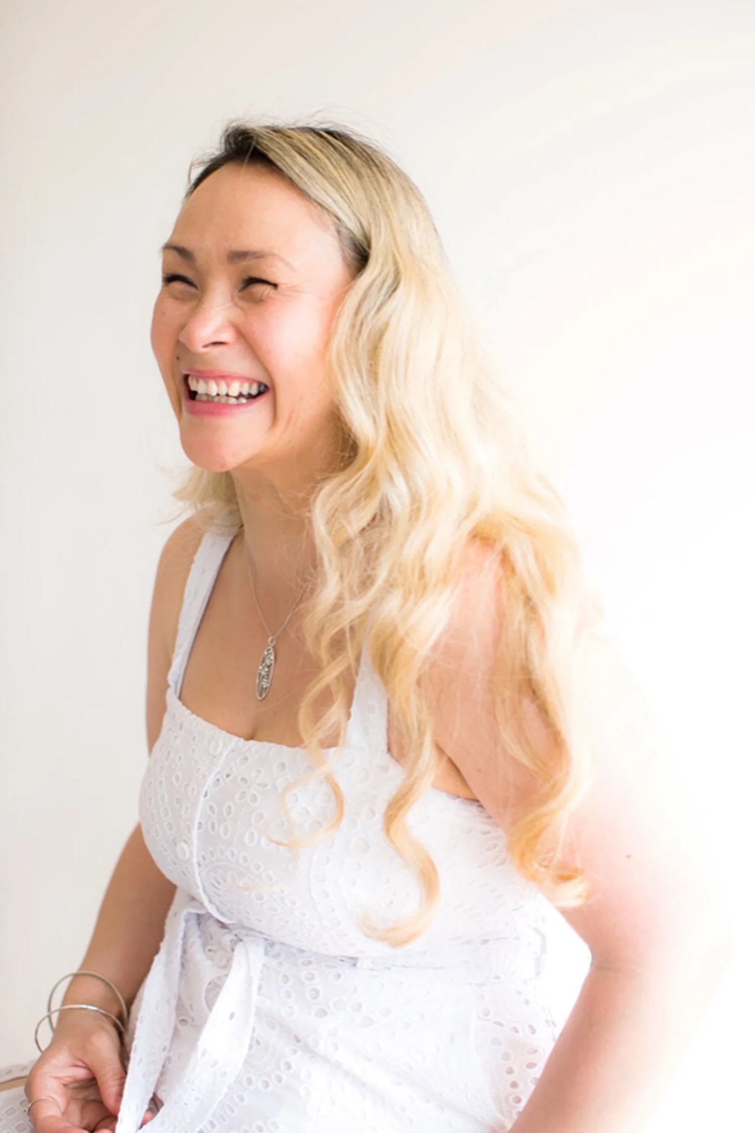 Kiki smiling, dressed in white